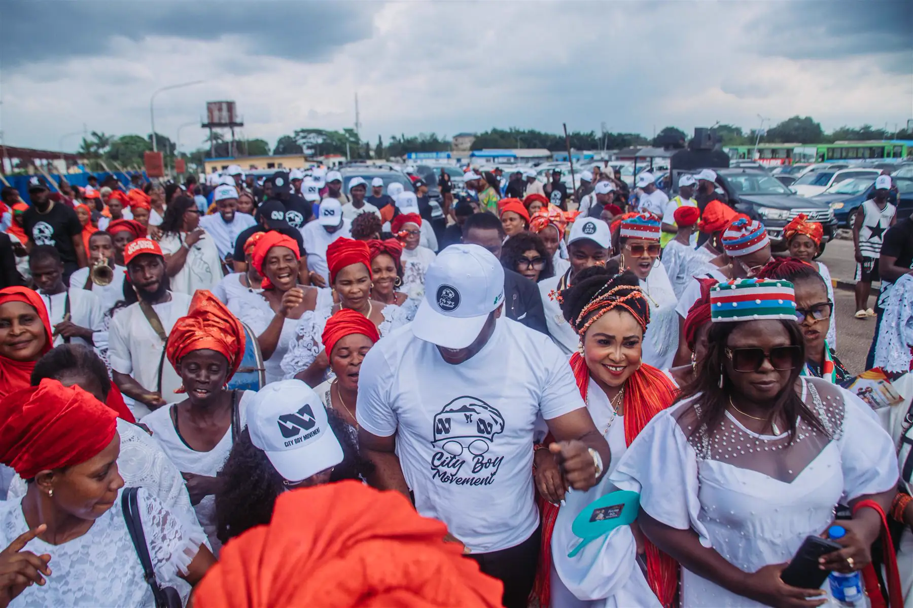 A large crowd in white and red with Dr Paddy Iyamu at its centre