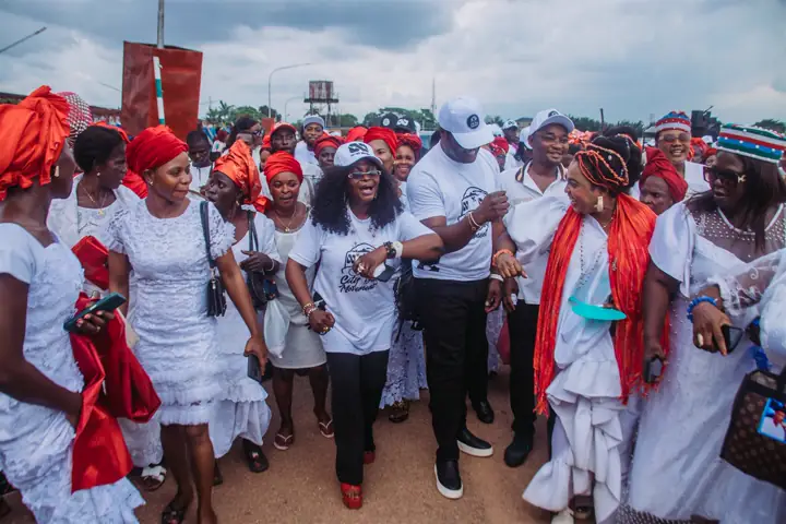 Dr Paddy Iyamu among women in white and red head ties
