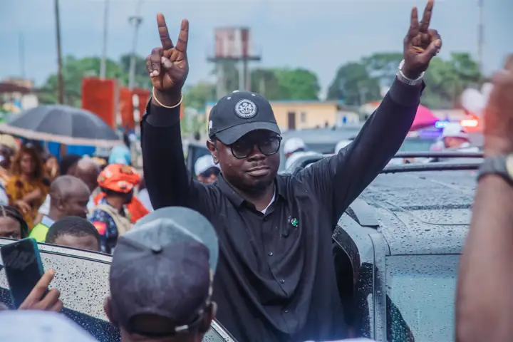 Dr Paddy Iyamu raising both hands in a victory sign