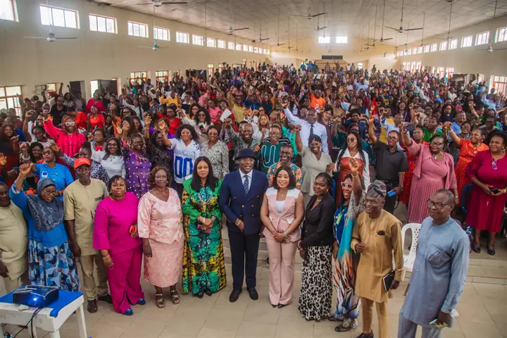 Dr Paddy Iyamu with women leaders and a large crowd in a hall